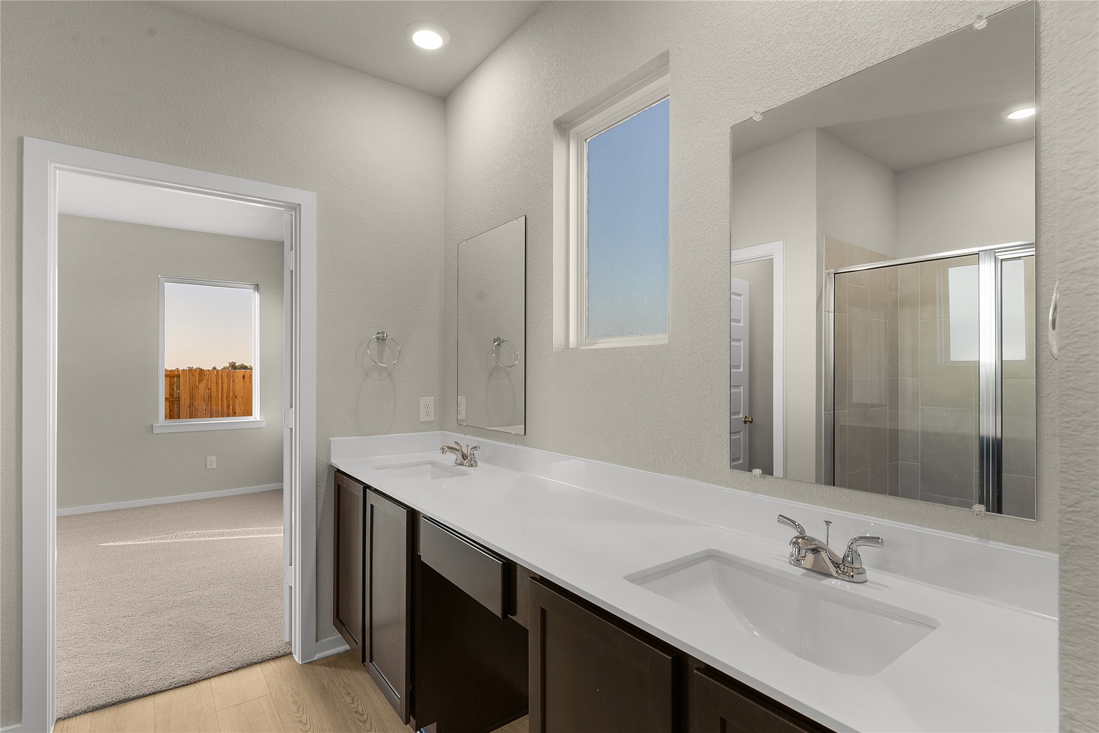 25628 Wheat Seed Lane Elgin, TX 78621 - Photo 4 of 20 Bathroom with double vanity, a shower stall, and light wood-type flooring