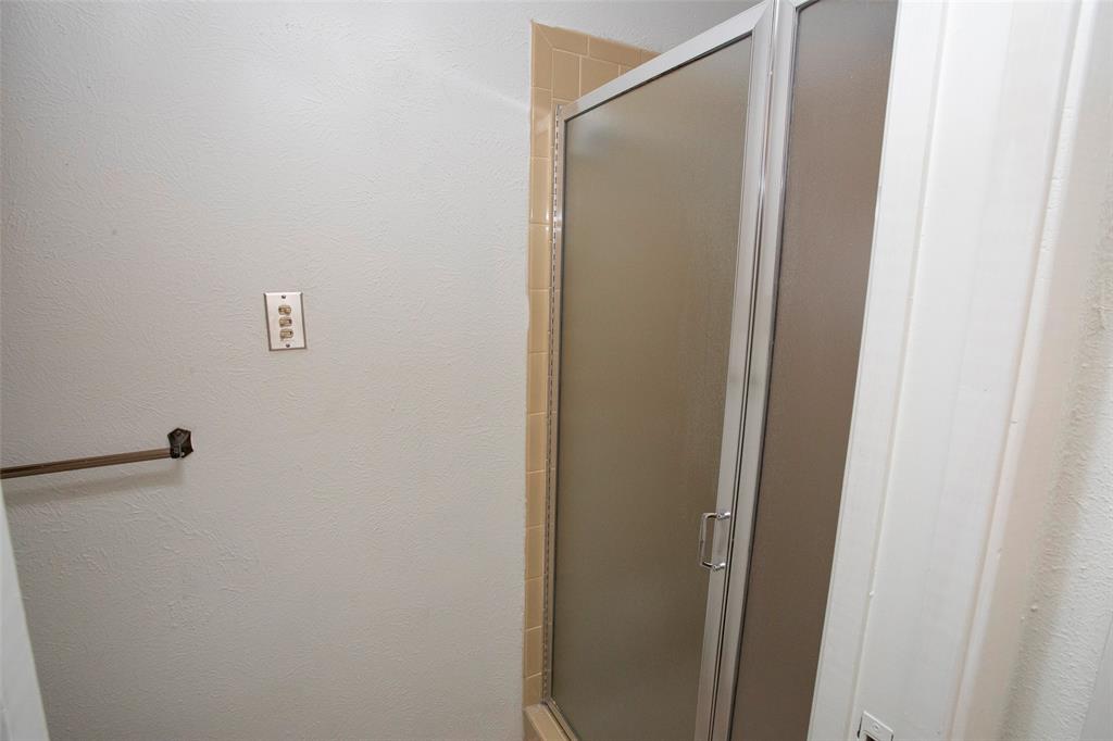 1202 Randy Drive Graham, TX 76450 - Photo 12 of 40 a bathroom with a glass shower door