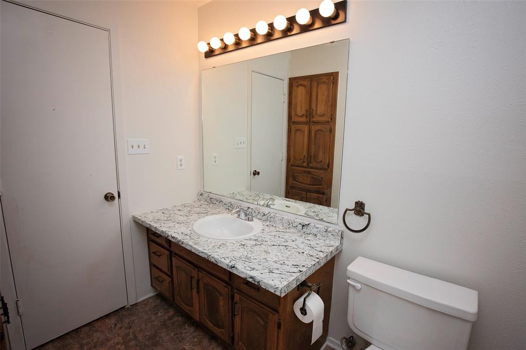 1202 Randy Drive Graham, TX 76450 - Photo 16 of 40 a bathroom with a granite countertop sink and a mirror