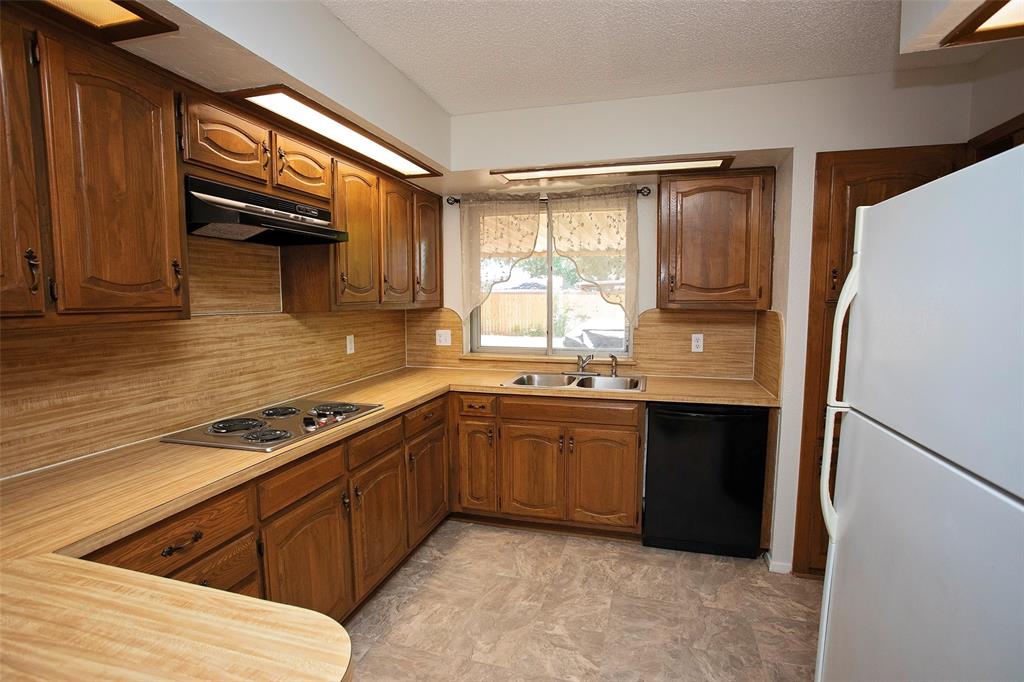 1202 Randy Drive Graham, TX 76450 - Photo 25 of 40 a kitchen with granite countertop a refrigerator and a sink
