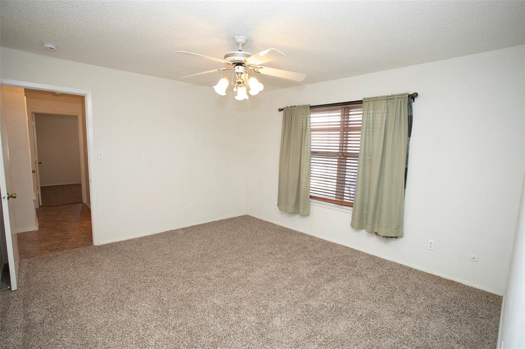 1202 Randy Drive Graham, TX 76450 - Photo 9 of 40 an empty room with windows and chandelier fan
