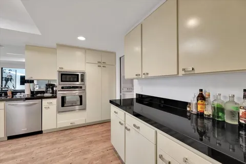 a kitchen with granite countertop white cabinets and white appliances
