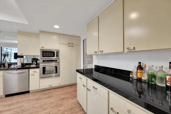 a kitchen with granite countertop white cabinets and white appliances