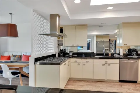a kitchen with granite countertop a sink a stove and cabinets