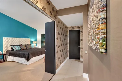 a bedroom with a large bed and a chandelier