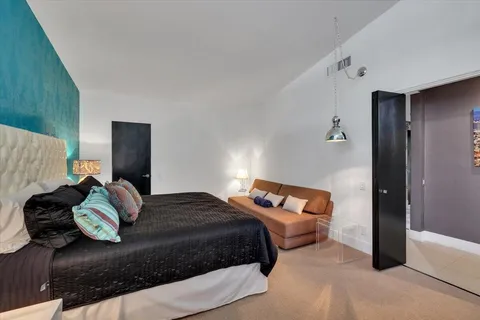 a bedroom with a bed and a dresser with rug