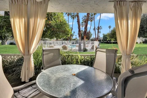 a view of a porch with chairs and backyard