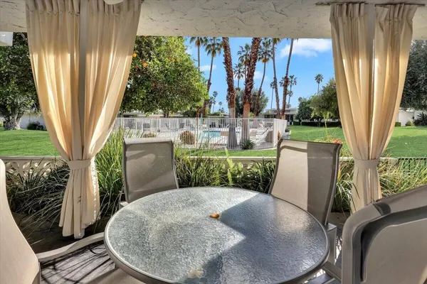 a view of a porch with chairs and backyard