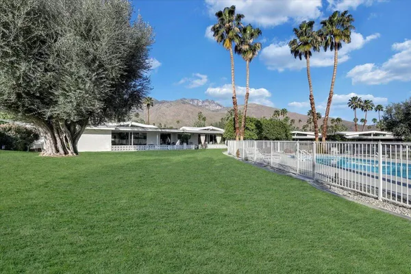 a view of a swimming pool with a patio and a yard