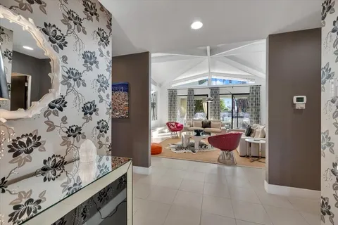 a view of a hallway with dining area and chandelier