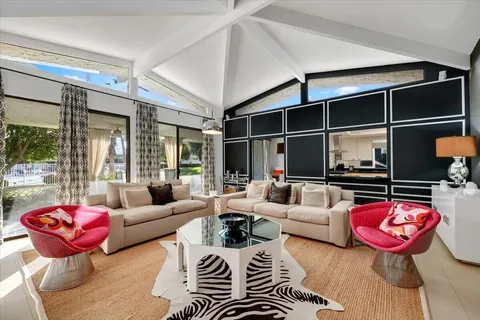 a living room with furniture fireplace and a large window