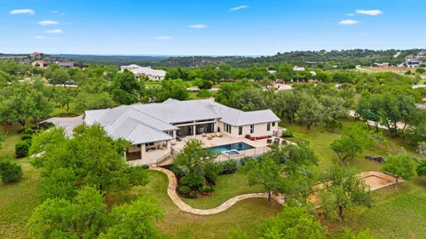 an aerial view of residential houses with outdoor space and trees
