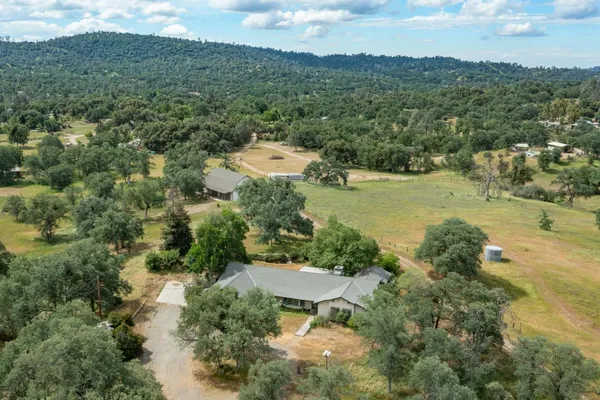 an aerial view of green landscape with trees houses and mountain view