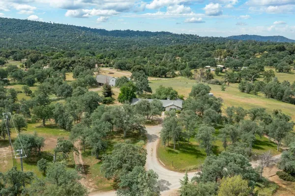 an aerial view of residential houses with outdoor space and trees