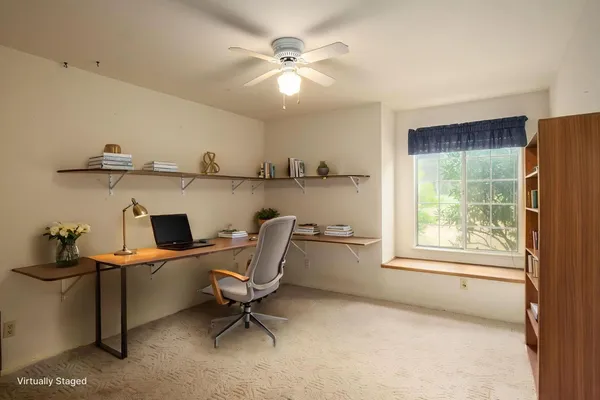 an empty room with windows and fan