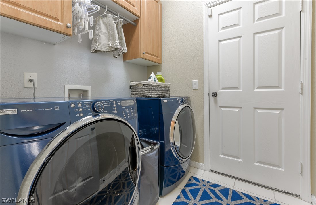 8249 Silver Birch Way Lehigh Acres, FL 33971 - Photo 18 of 19 a bathroom with a sink a washer and dryer