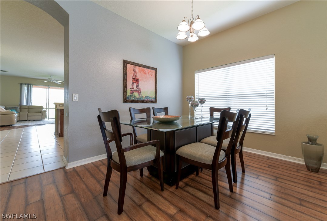8249 Silver Birch Way Lehigh Acres, FL 33971 - Photo 10 of 19 a view of a dining room with furniture wooden floor and a chandelier