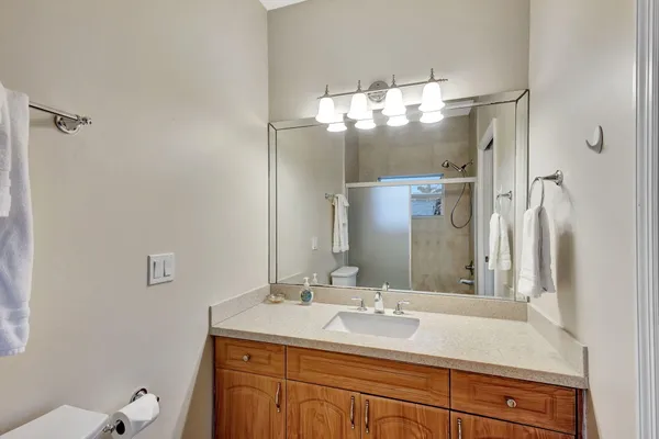 a bathroom with a sink vanity granite and toilet