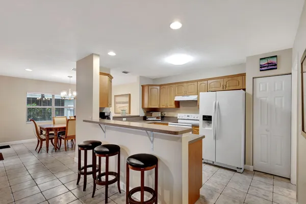 a kitchen with refrigerator and chairs
