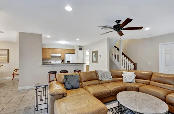 a living room with furniture and a ceiling fan