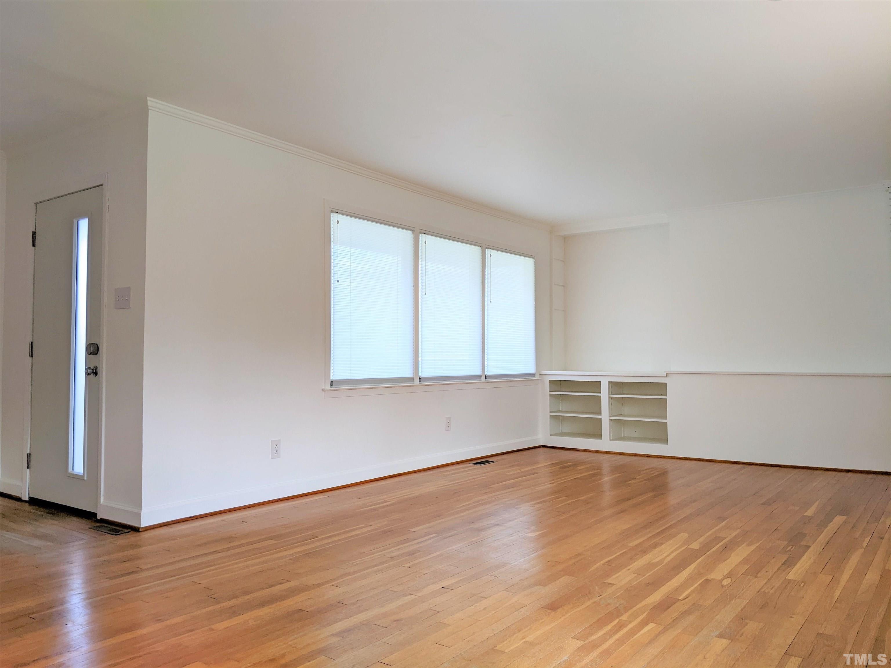 630 Smedes Place Raleigh, NC 27605 - Photo 4 of 9 an empty room with wooden floor and windows