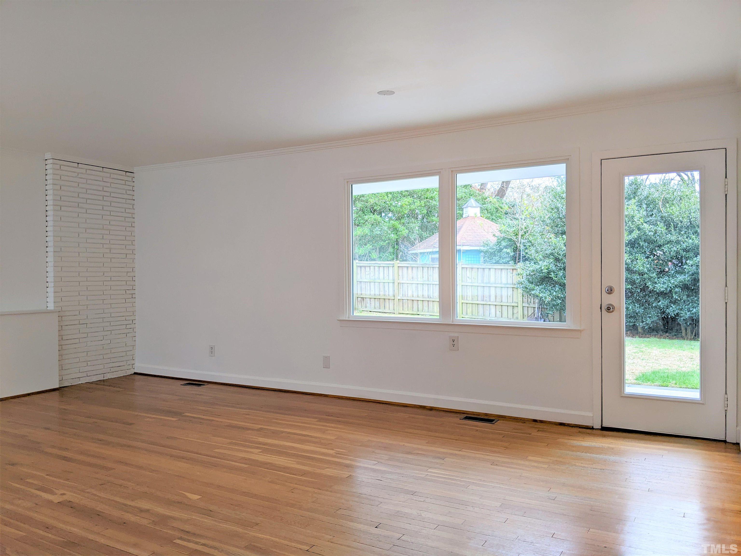 630 Smedes Place Raleigh, NC 27605 - Photo 5 of 9 a view of an empty room with wooden floor and a window