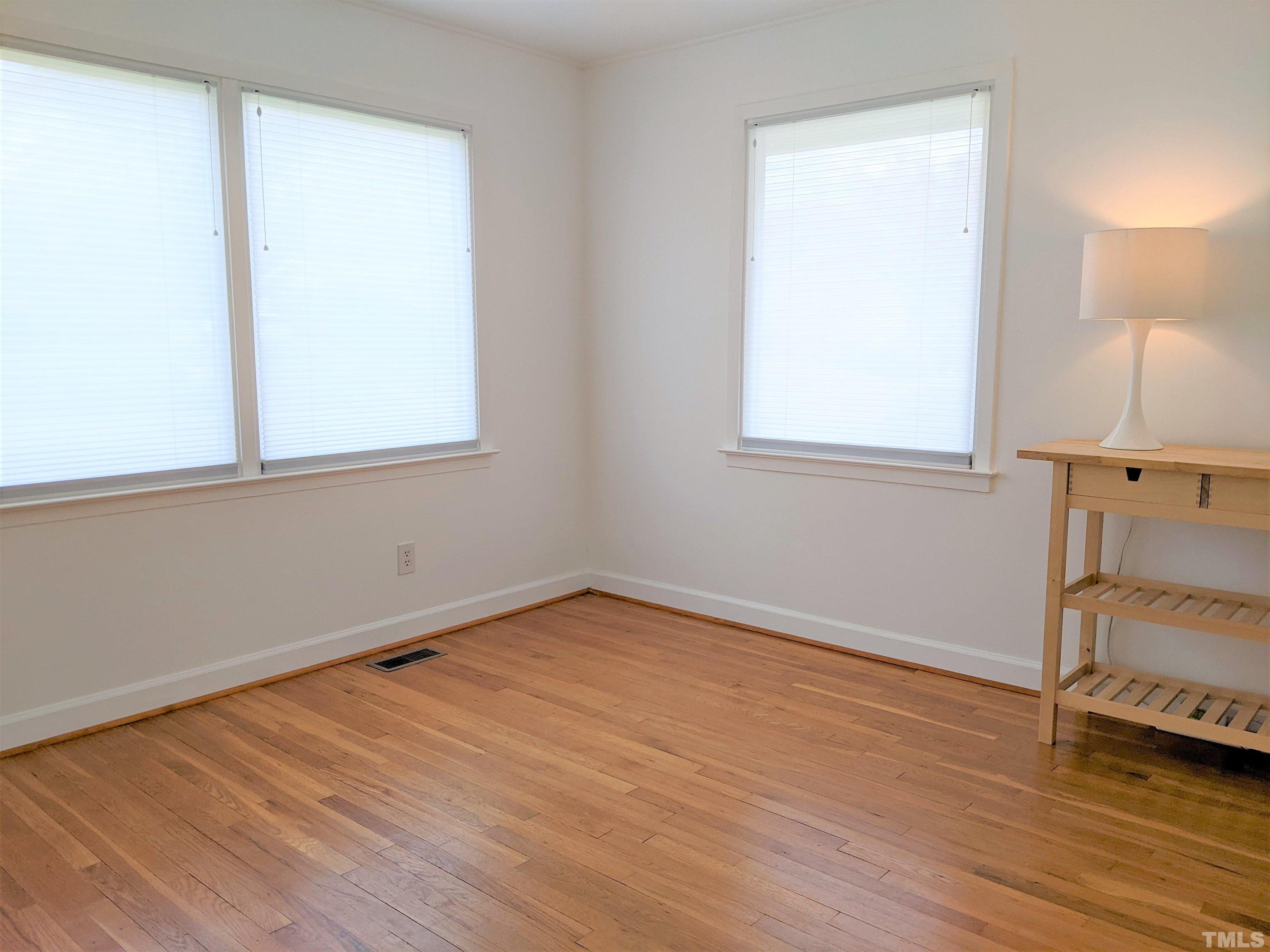 630 Smedes Place Raleigh, NC 27605 - Photo 7 of 9 an empty room with wooden floor and windows
