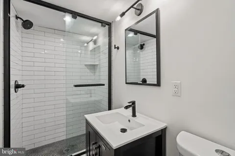 a bathroom with a sink a toilet and mirror