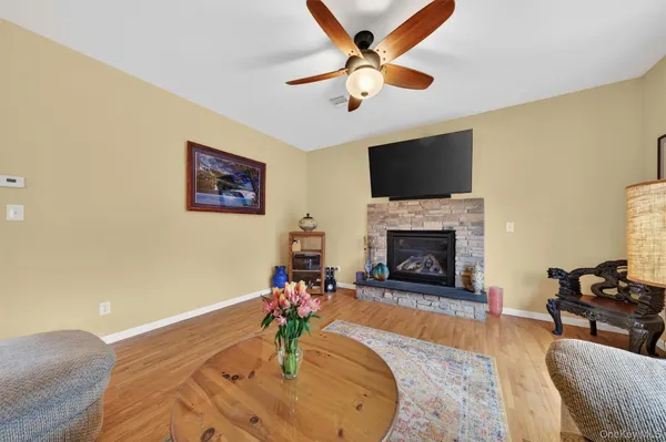 a living room with furniture a flat screen tv and a fireplace