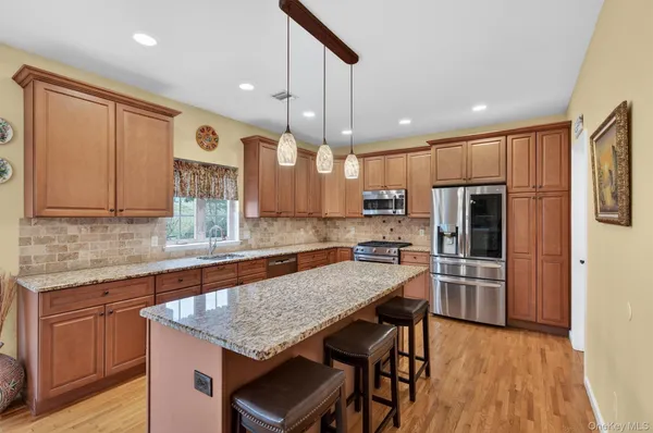 a kitchen with granite countertop a table chairs sink and wooden floor
