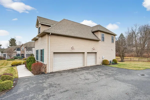a front view of house with yard and trees in the background