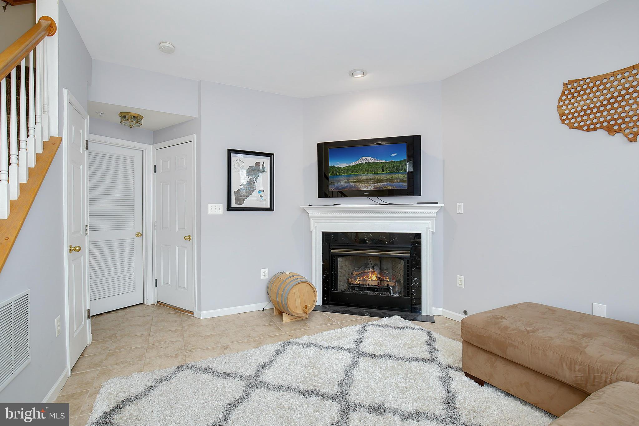 5806 Summers Grove Road Alexandria, VA 22304 - Photo 2 of 30 a living room with furniture a flat screen tv and a fireplace