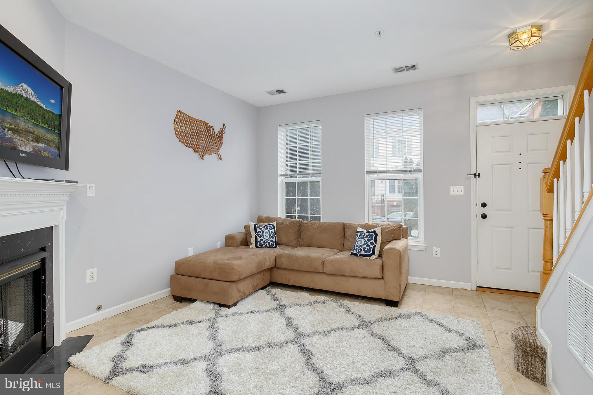 5806 Summers Grove Road Alexandria, VA 22304 - Photo 4 of 30 a living room with furniture a flat screen tv and a fireplace