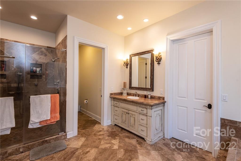 4597 Hickory Nut Ridge Road Granite Falls, NC 28630 - Photo 31 of 48 a bathroom with a double vanity sink a mirror and a shower