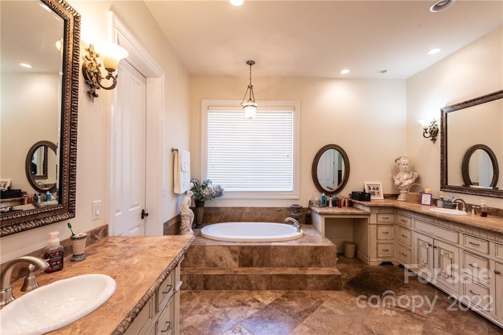 4597 Hickory Nut Ridge Road Granite Falls, NC 28630 - Photo 32 of 48 a bathroom with a double vanity sink a mirror a vanity and a window