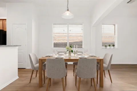 a dining room with furniture a chandelier and wooden floor