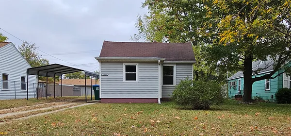 a view of a house with a yard and large tree