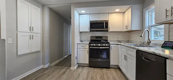 a kitchen with a sink a stove and cabinets