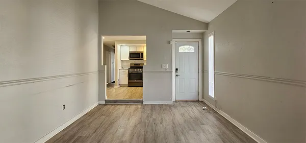a view of empty room with wooden floor