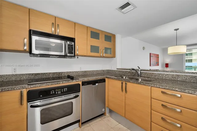 a kitchen with granite countertop cabinets stainless steel appliances and a sink
