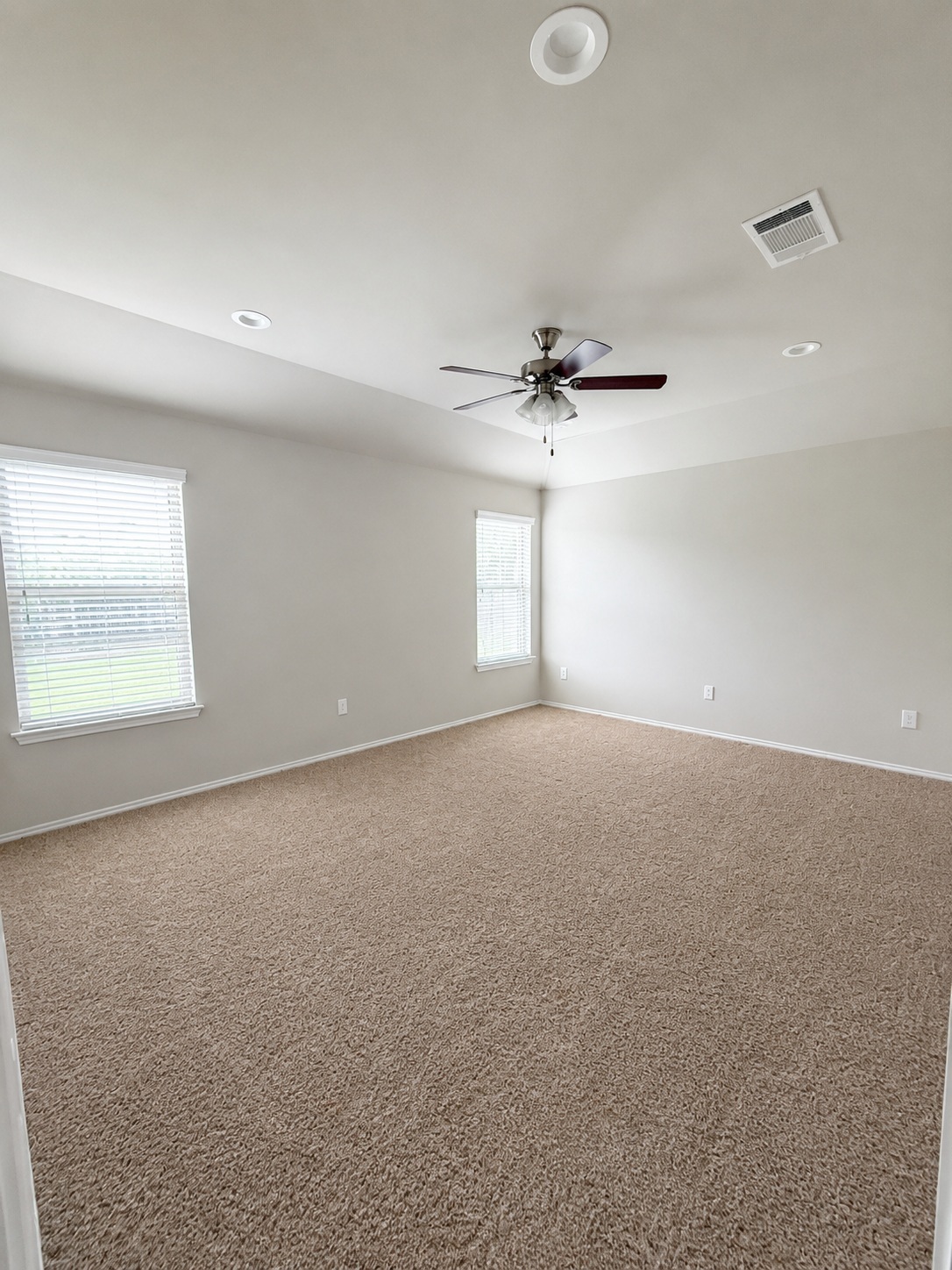 187 Limerick Road Buda, TX 78610 - Photo 7 of 18 A spacious, airy bedroom features plush carpeting, recessed lighting, and ample natural illumination from multiple windows.