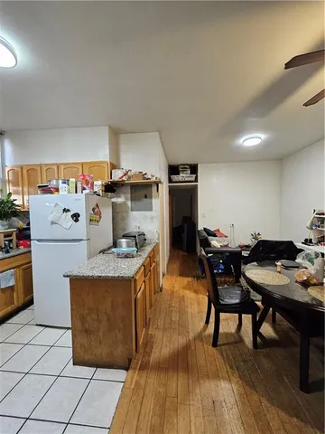a open kitchen with stainless steel appliances kitchen island granite countertop a table chairs and a refrigerator