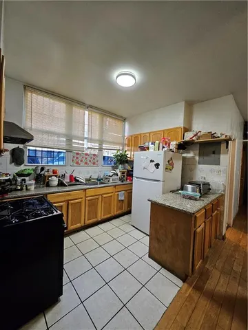 a kitchen with stainless steel appliances granite countertop a stove top oven a sink dishwasher and cabinets with wooden floor