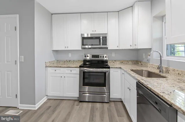 a kitchen with stainless steel appliances granite countertop a stove a sink and a microwave