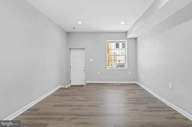 wooden floor in an empty room with a window