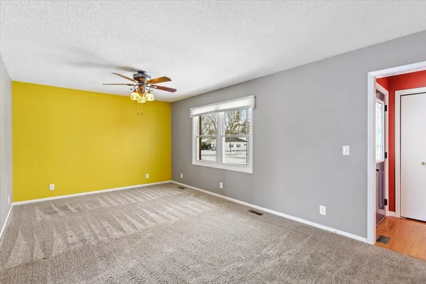 a view of a big room with windows and chandelier fan