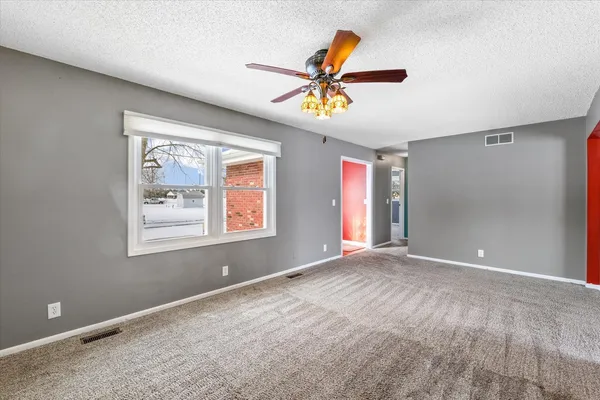 a view of a livingroom with a ceiling fan and window