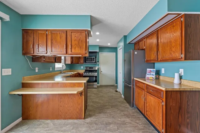 a kitchen with stainless steel appliances granite countertop a stove a sink and a refrigerator