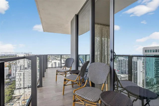 a view of a workspace with furniture and floor to ceiling window