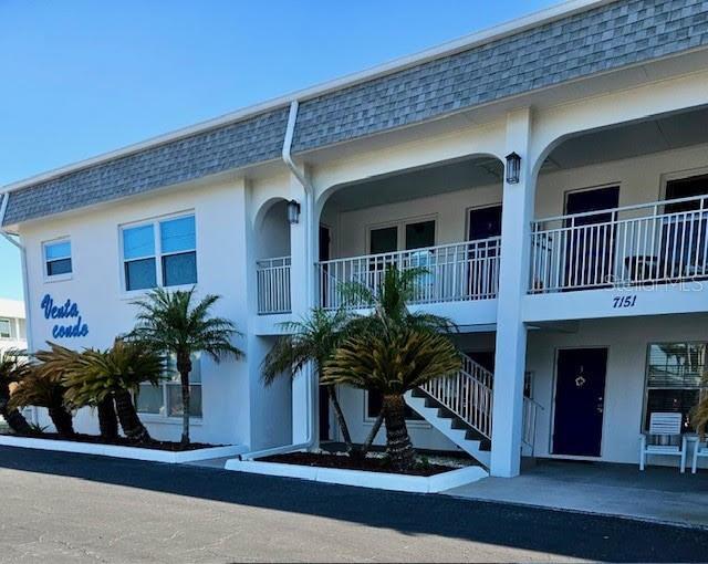 a view of house with a potted plant and a table and chairs